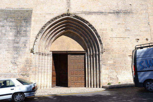 Façade romane de la concathédrale Notre-Dame-du-Bourguet de Forcalquier, clocher carré et portail principal en pierre.