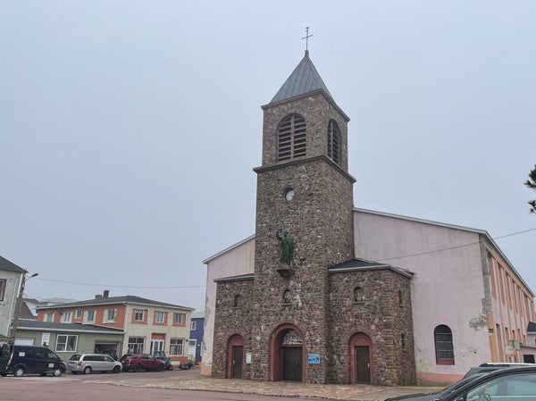 Cathédrale Saint-Pierre de Saint-Pierre-et-Miquelon, façade et clocher de pierre, ciel nuageux